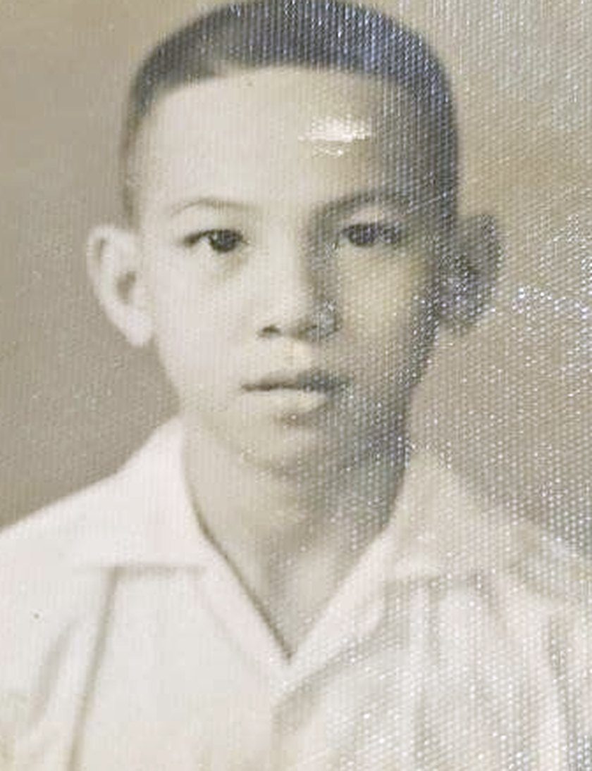 A studio portrait of Tommy as a young boy in a white collared shirt.
