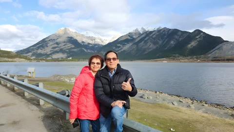 Tommy and Phuong together by a mountain lake.